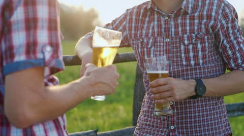 Friends drinking beer in the evening, at sunset the sun shines beautifully on Stock-Footage 65455198