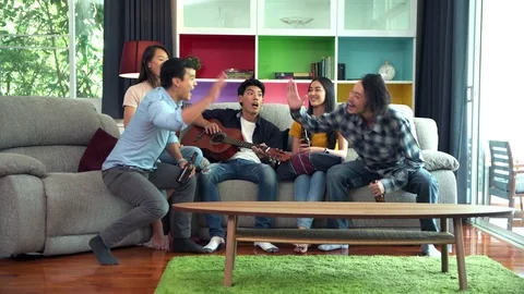 Friends drinking beers on sofa. House party. Stock Footage 99015813