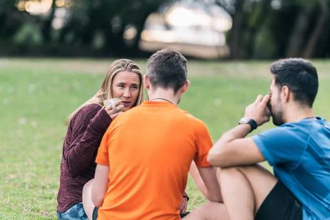 Friends drinking tea after doing yoga in a park Stock Photos