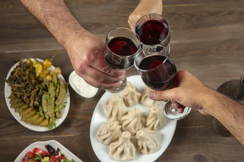 Friends drinking wine over table served with traditional Georgian dishes - ,  Stock Photos