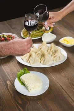 Friends drinking wine over table served with traditional Georgian dishes - ,  Stock Photos