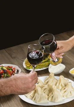 Friends drinking wine over table served with traditional Georgian dishes - ,  Stock Photos