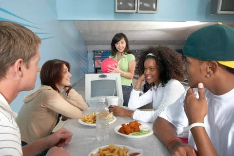 Friends Eating At Bowling Alley Stock Photos