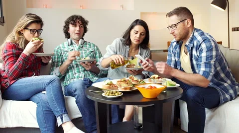 Friends eating dinner in the flat and talking with each other Stock-Footage 62973139