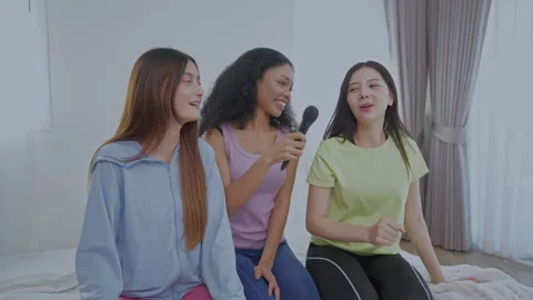 Friends enjoy a fun karaoke session at home Video stock 303804053