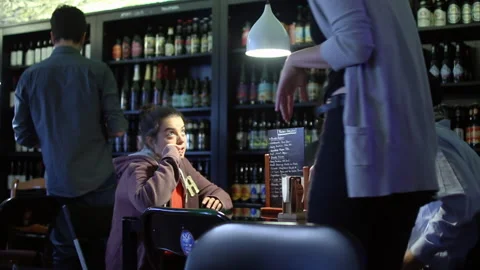 Friends Enjoying Drinks and Conversation in Cozy Local Bar 库存影片 344322075