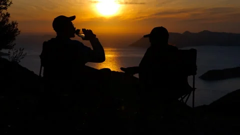 Friends enjoying drinks at sunset overlooking tranquil ocean Stock Footage 319086735