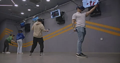 Friends Enjoying Immersive Virtual Reality Gaming Experience at Entertainment Видео 312760039