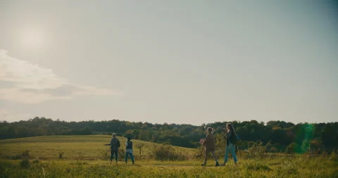 Friends Exploring Meadow While Walking Against Sky Stock Footage 251991661