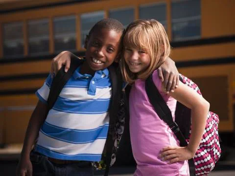 Friends in front of school bus Stock Photos