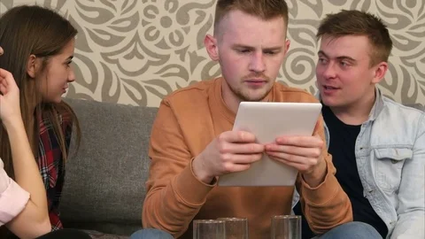 Friends gathering at home and using tablet Vidéo 73482462