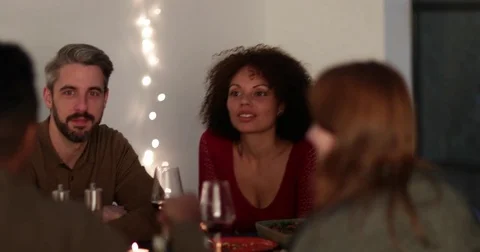 Friends giving a gift of wine at a dinner party Stock Footage 80809876