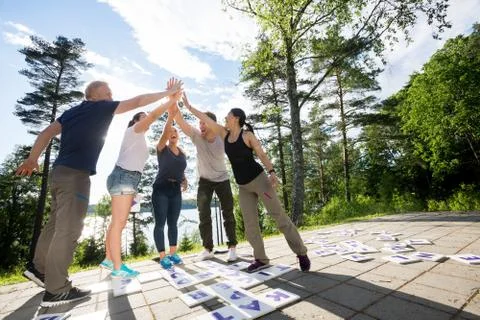 Friends Giving High-Five After Solving Crossword Puzzle On Patio Stock Photos