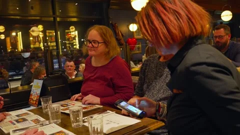 Friends group at dinner restaurant pub table indoor cozy atmosphere together Stock Footage 310176514