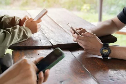 Friends group having addicted fun using mobile smart phone outside. Stock Photos