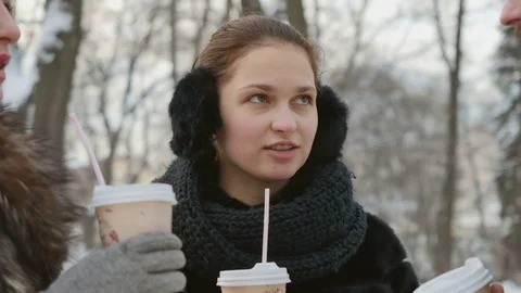 The friends have a conversation and drinks coffe in winter park Stock Footage
