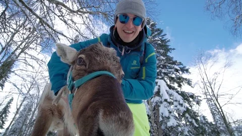 Friends have fun on the ski resort. Man feed deer. Deer farm. Winter deer. Side Video stock 121363689