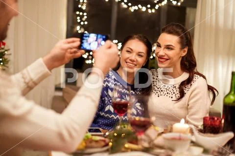Friends having christmas dinner and taking picture Stock Photos