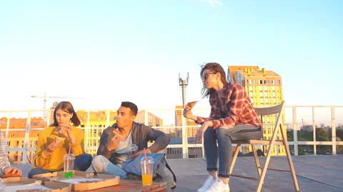 Friends having dinner or BBQ, or pizza party on rooftop. Stock Footage 112579336