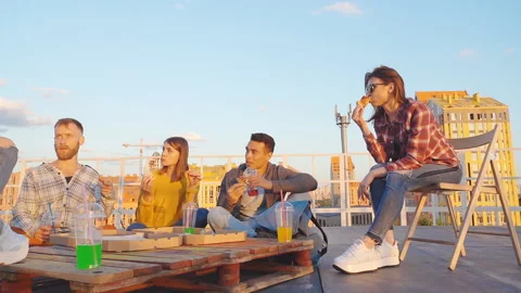 Friends having dinner or BBQ, or pizza party on rooftop. Stock Footage 112579510