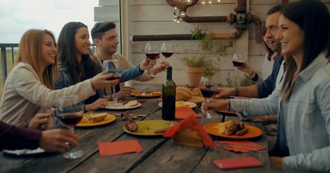 Friends having dinner together on the rooftop at home. Shot in slow motion Stock Footage 117183385