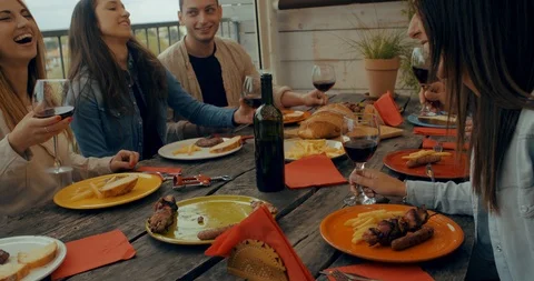 Friends having dinner together on the rooftop at home. Shot in slow motion Stock Footage 117183425