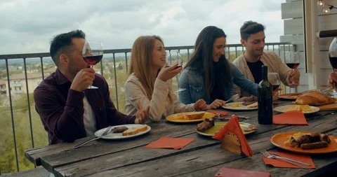 Friends having dinner together on the rooftop at home. Shot in slow motion Stock Footage 117183452