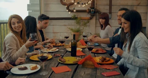 Friends having dinner together on the rooftop at home. Shot in slow motion Video stock 118066626