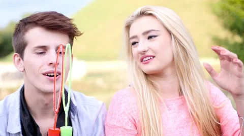 Friends having fun and blowing soap bubbles in park. Stock Footage 53484243