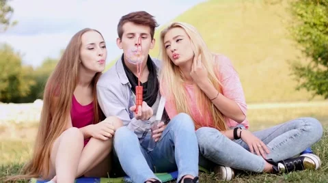 Friends having fun and blowing soap bubbles in park. Stock-Footage 53829846