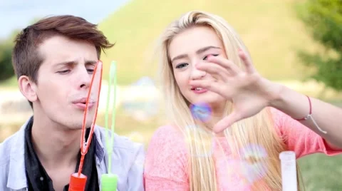 Friends having fun and blowing soap bubbles in park. Stock-Footage 53829898