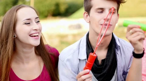 Friends having fun and blowing soap bubbles in park. Stock Footage 55232773