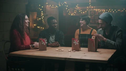 Friends having fun and opening Christmas presents at a pub Stock Footage 132014462