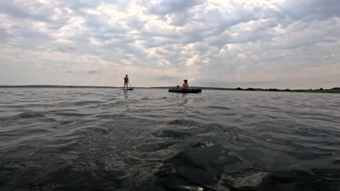 Friends having fun on the lake floating on supboard and mattress Stock Footage 262416420
