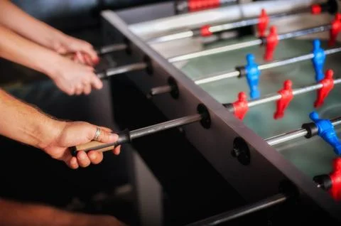 Friends having fun playing table foosball Stock Photos