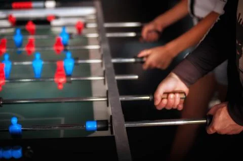 Friends having fun playing table foosball Stock Photos