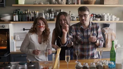 Friends is having a fun with spaghetti on a kitchen party Stock Footage 73589923