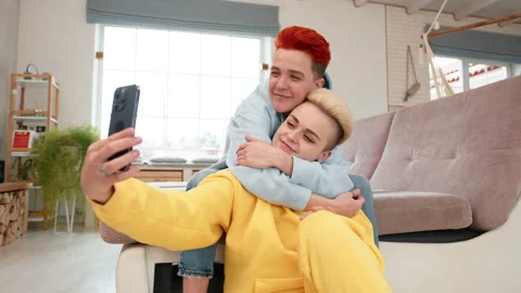 Friends having fun, taking selfies at home in casual outfits in a cozy living Stock Footage 277024081