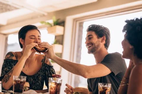 Friends having stack burger at cafe Foto stock