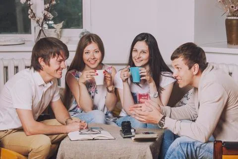 Friends at home and communicate via the process of drinking tea Stock Photos