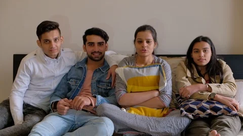 Friends at home on a bed looking straight at the camera pov and talking to one Stock Footage 101232541