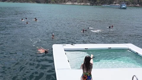 Friends in an inflatable pool at sea while traveling on a yacht Stock Footage 275344840