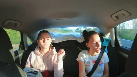 Friends inside the car singing during a road trip at back seat on sunny day Stock Footage 122767570