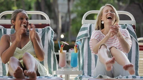 Friends laughing and clapping on deck chairs. 스톡 동영상 88368239