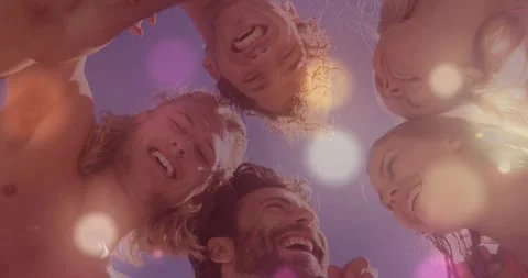 Friends leaning over low camera filming, sun glare creating flares, revealing Video stock 329908986