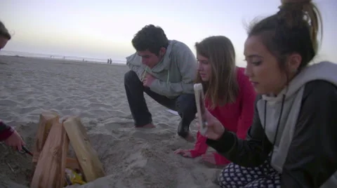 Friends light fire at the beach Stock Footage 53076483
