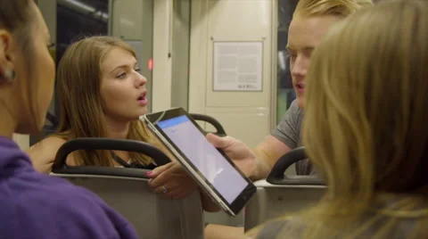 Friends look at iPad on train Stock Footage 54261508