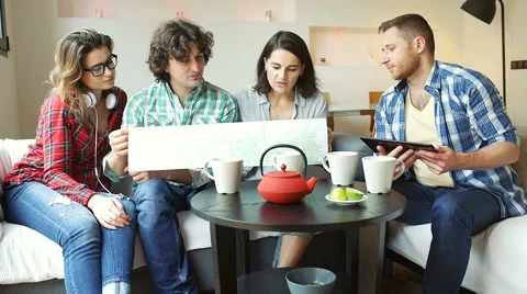 Friends looking on the map and comparing it with the tablet Stock Footage 62973106