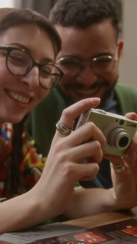 Friends Looking Through Camera Photos During Game Night Stock Footage 335859294