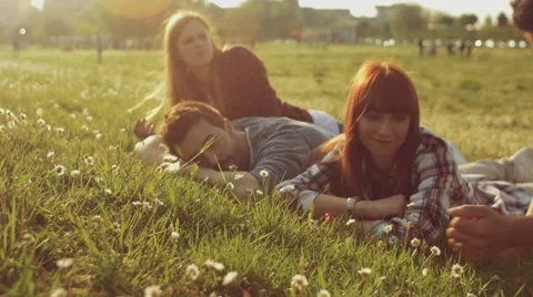 Friends lying on grass in the park Stock Footage 62777273